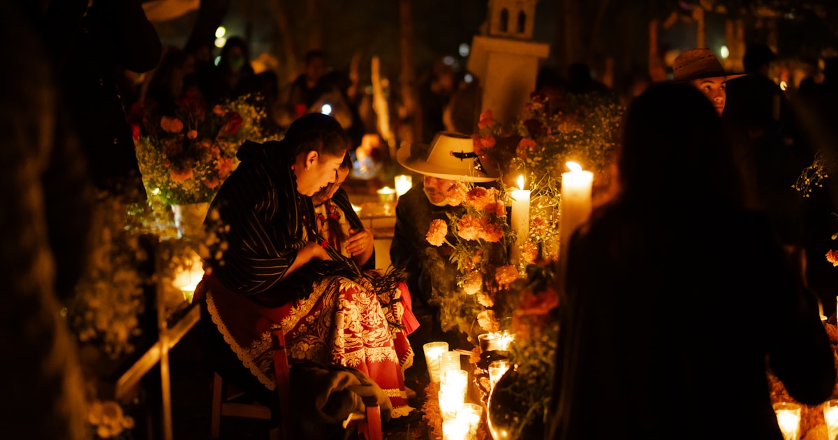 A group of people standing around a bunch of candles