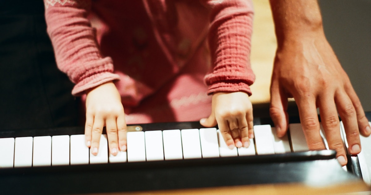 person in red long sleeve shirt playing piano