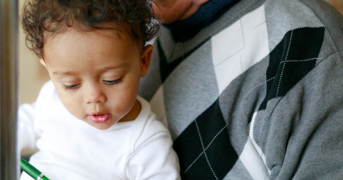 man carrying baby close-up photography