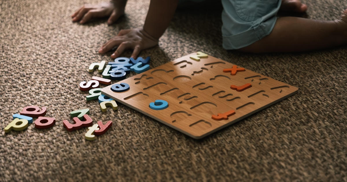 Child playing with alphabet puzzle on carpet