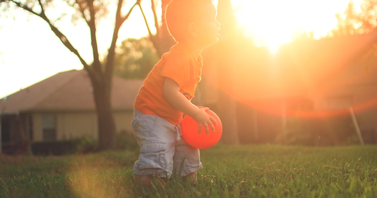 boy holding orange balloon