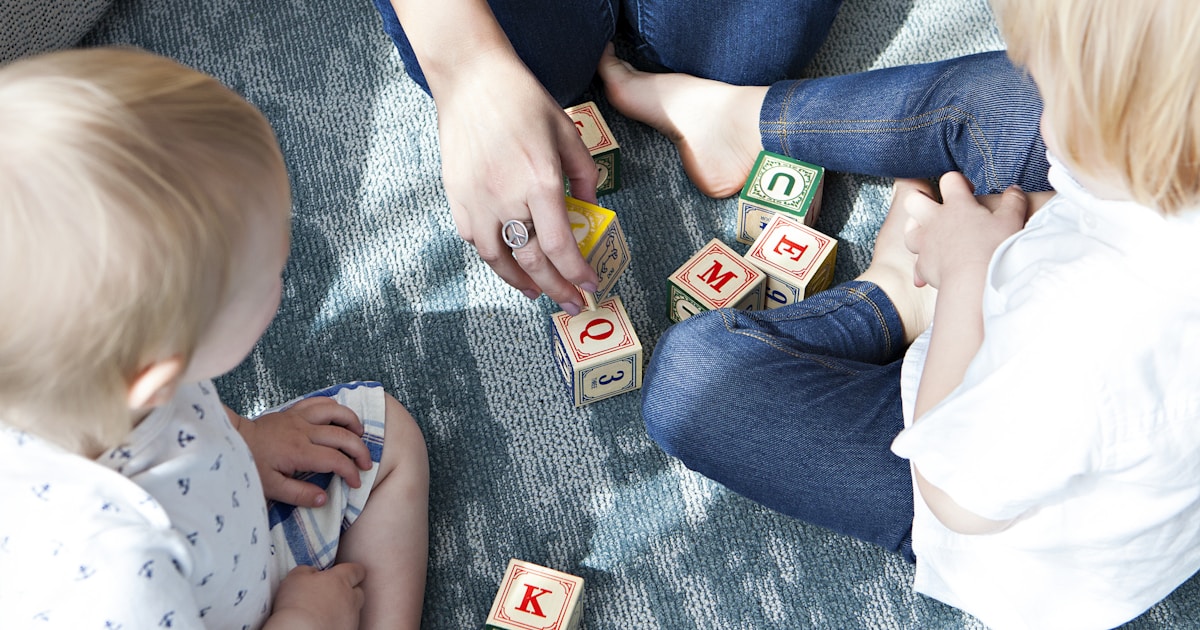 two toddler playing letter cubes