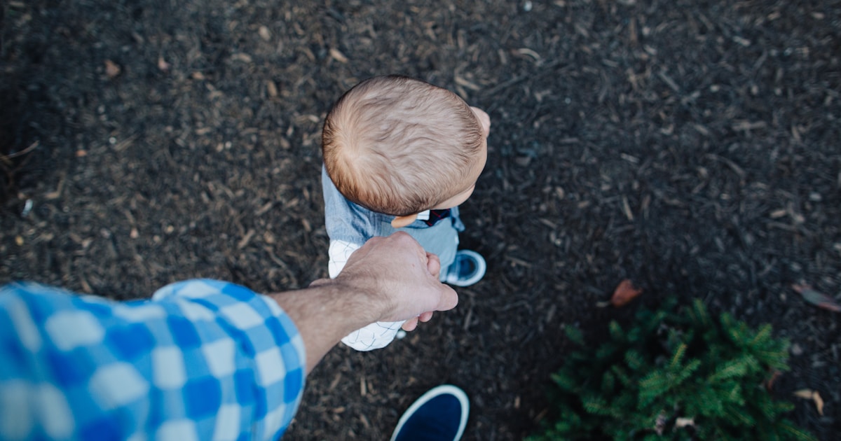 boy in blue and white striped shirt holding blue and white ball
