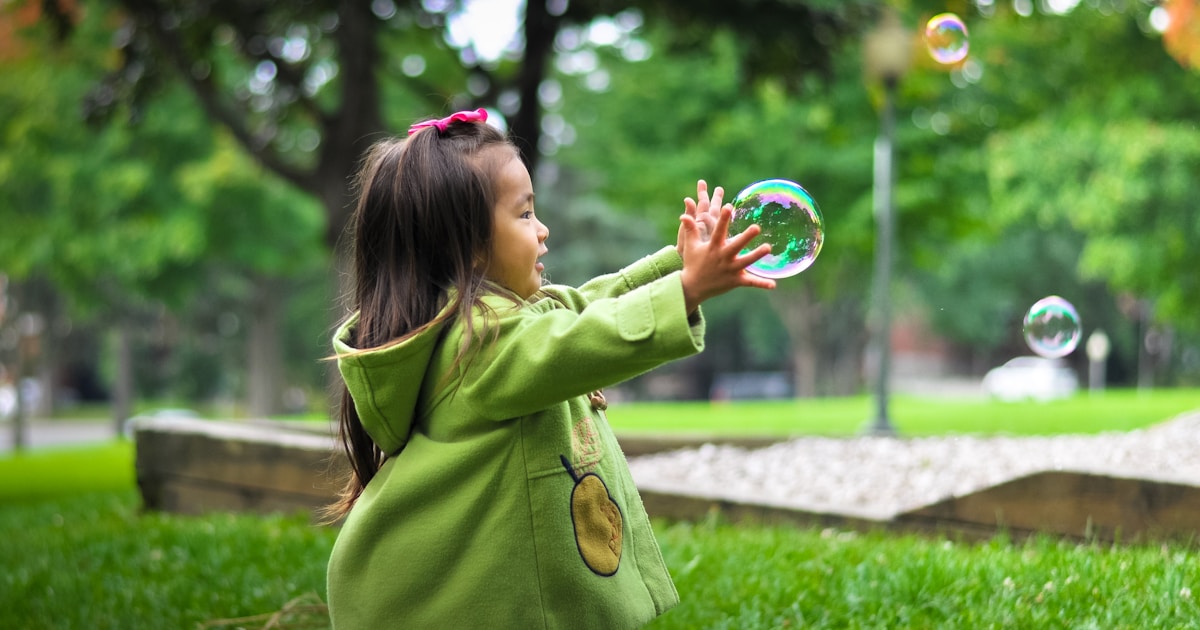 selective photo of a girl holding bubbles